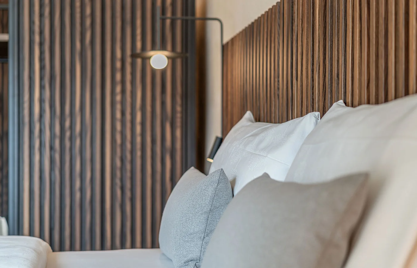 Suite III Minerva: Bett vor der Holzwand – Ansitz Romani in Tramin, Südtirol