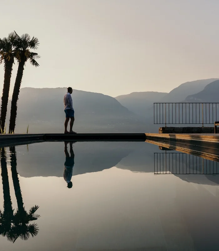 Bio-Pool des Ansitz Romani mit Palmen im Abendlicht – Hotel in Tramin, Südtirol