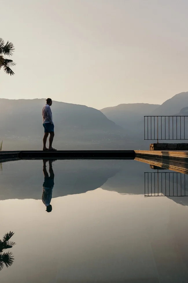 Bio-Pool des Ansitz Romani mit Palmen im Abendlicht – Hotel in Tramin, Südtirol