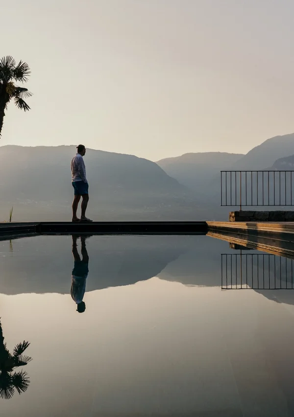Bio-Pool des Ansitz Romani mit Palmen im Abendlicht – Hotel in Tramin, Südtirol