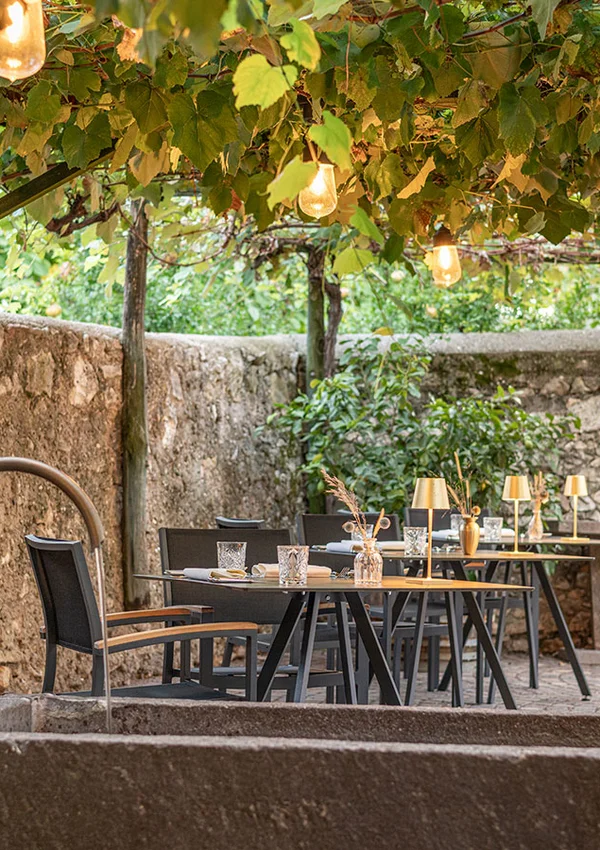 Terrasse des Haubenrestaurants Ansitz Romani unter Weinreben – Tramin, Südtirol