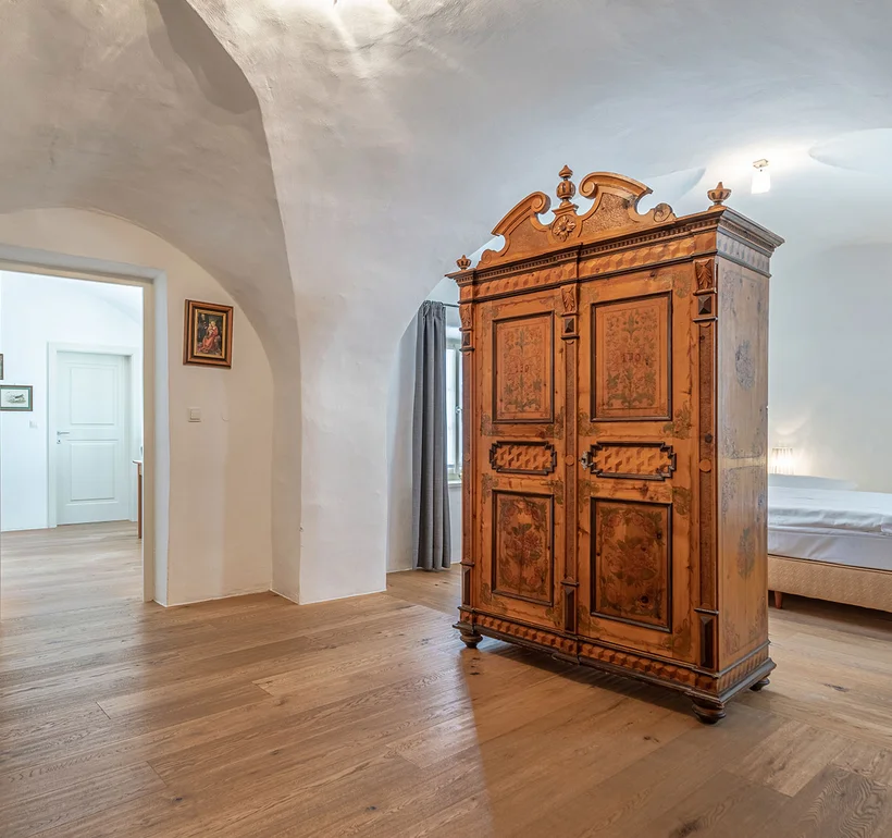 Zimmer I Somnus: antiker Kleiderschrank unter der Gewölbedecke – Ansitz Romani, Tramin