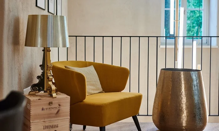 Sitzecke mit gelbem Sessel im Ansitz Romani – Hotel in Tramin, Südtirol