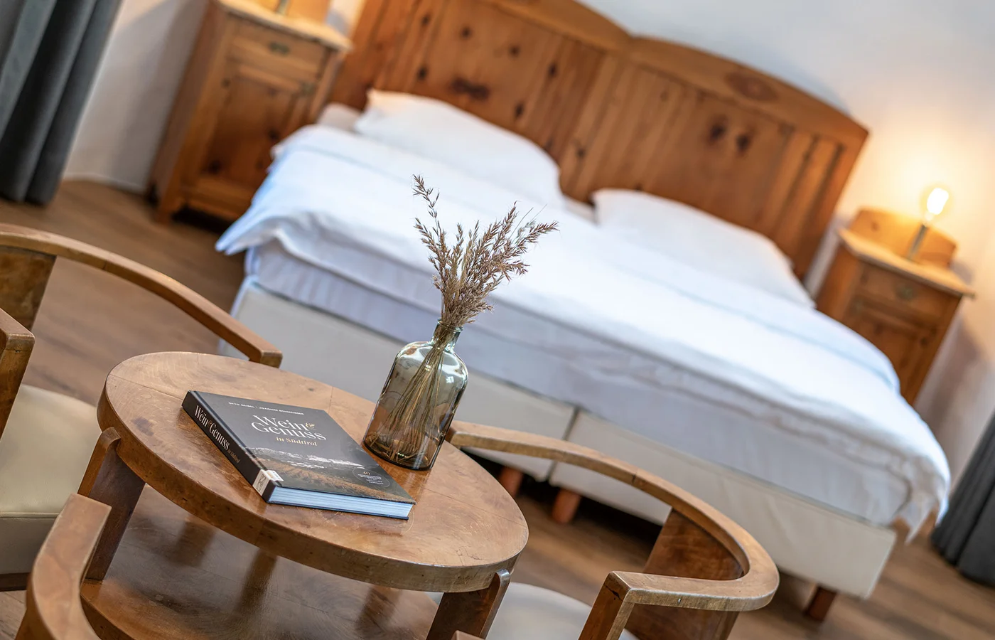 Appartement VI Herakles: Bett mit Beistelltisch und Blumen – Ansitz Romani in Tramin, Südtirol
