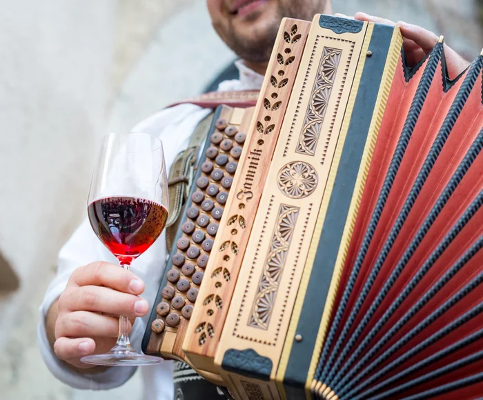 Ziehharmonika-Spieler mit Glas Rotwein – Weinfest in Tramin, Südtirol