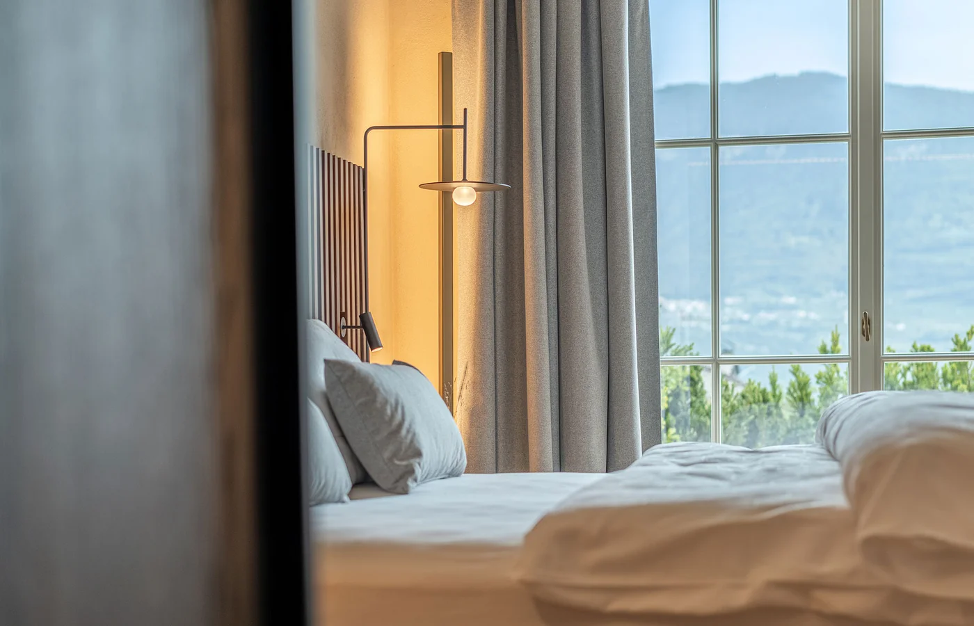 Suite I Minerva: Bett mit Blick auf die Berge – Ansitz Romani in Tramin, Südtirol