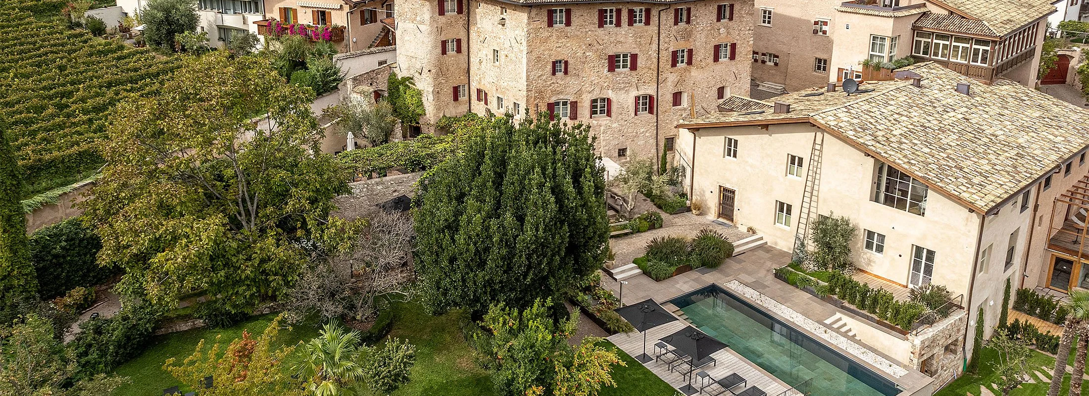 Luftaufnahme des Ansitz Romani in Tramin mit Bio-Pool und Weinbergen – Südtirol