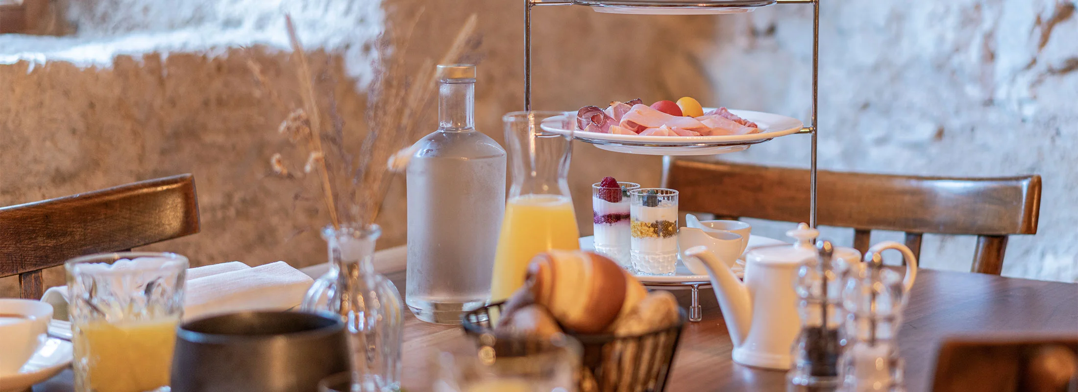 Frühstück auf der Terrasse des Ansitz Romani mit Blick ins Grüne – Hotel in Tramin, Südtirol