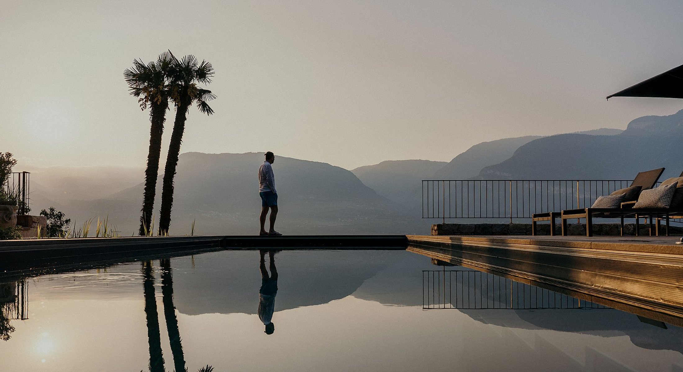 Gast am Bio-Pool des Ansitz Romani mit Blick auf die Berge – Hotel in Tramin, Südtirol