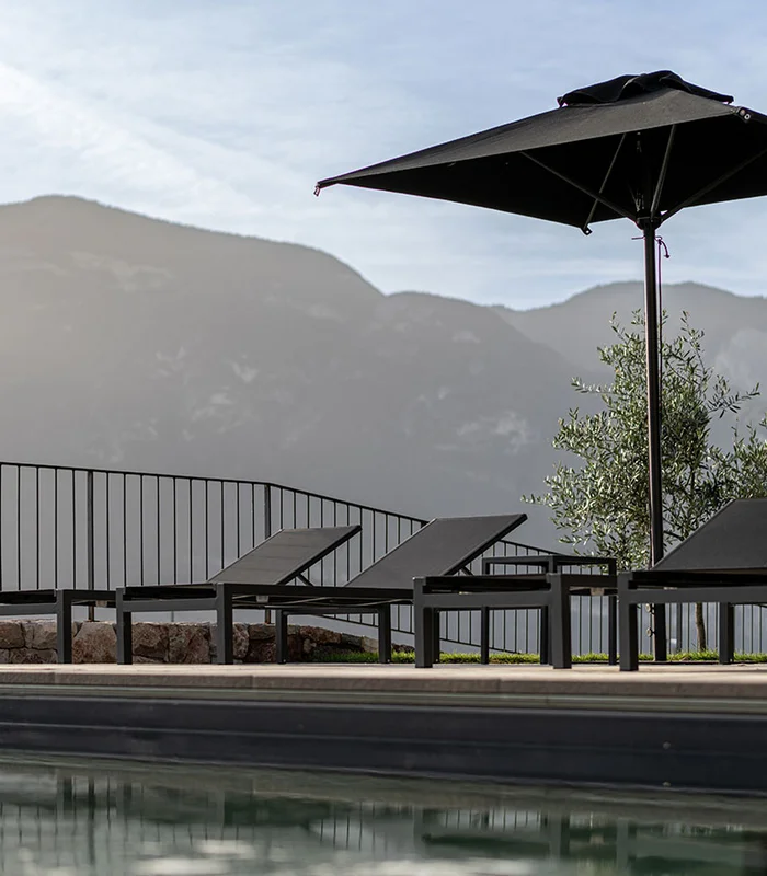 Bio-Pool mit Liegen und Sonnenschirm im Ansitz Romani – Hotel in Tramin, Südtirol