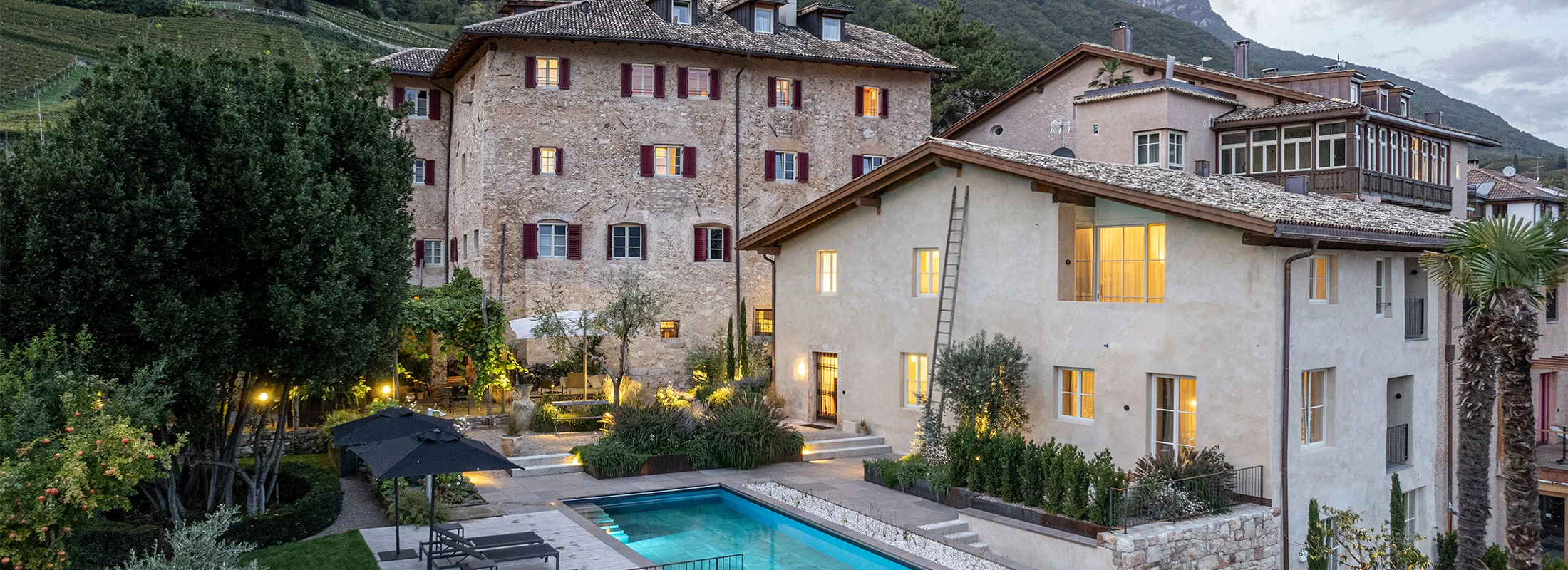 Ansitz Romani in Tramin am Abend mit beleuchtetem Bio-Pool – Hotel in Südtirol