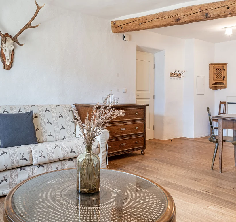 Appartement IV Apollo: Wohnzimmer mit Sofa und Hirschgeweih – Ansitz Romani in Tramin, Südtirol
