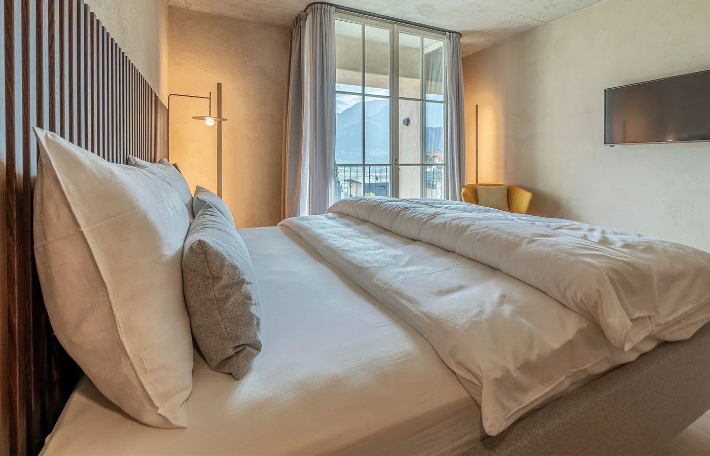 Suite III Minerva: Bett mit Kissen und Sideboard – Ansitz Romani in Tramin, Südtirol