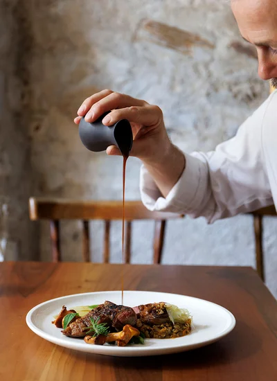 Haubenrestaurant Ansitz Romani: Anrichten eines Gerichts – regionale Küche in Tramin, Südtirol