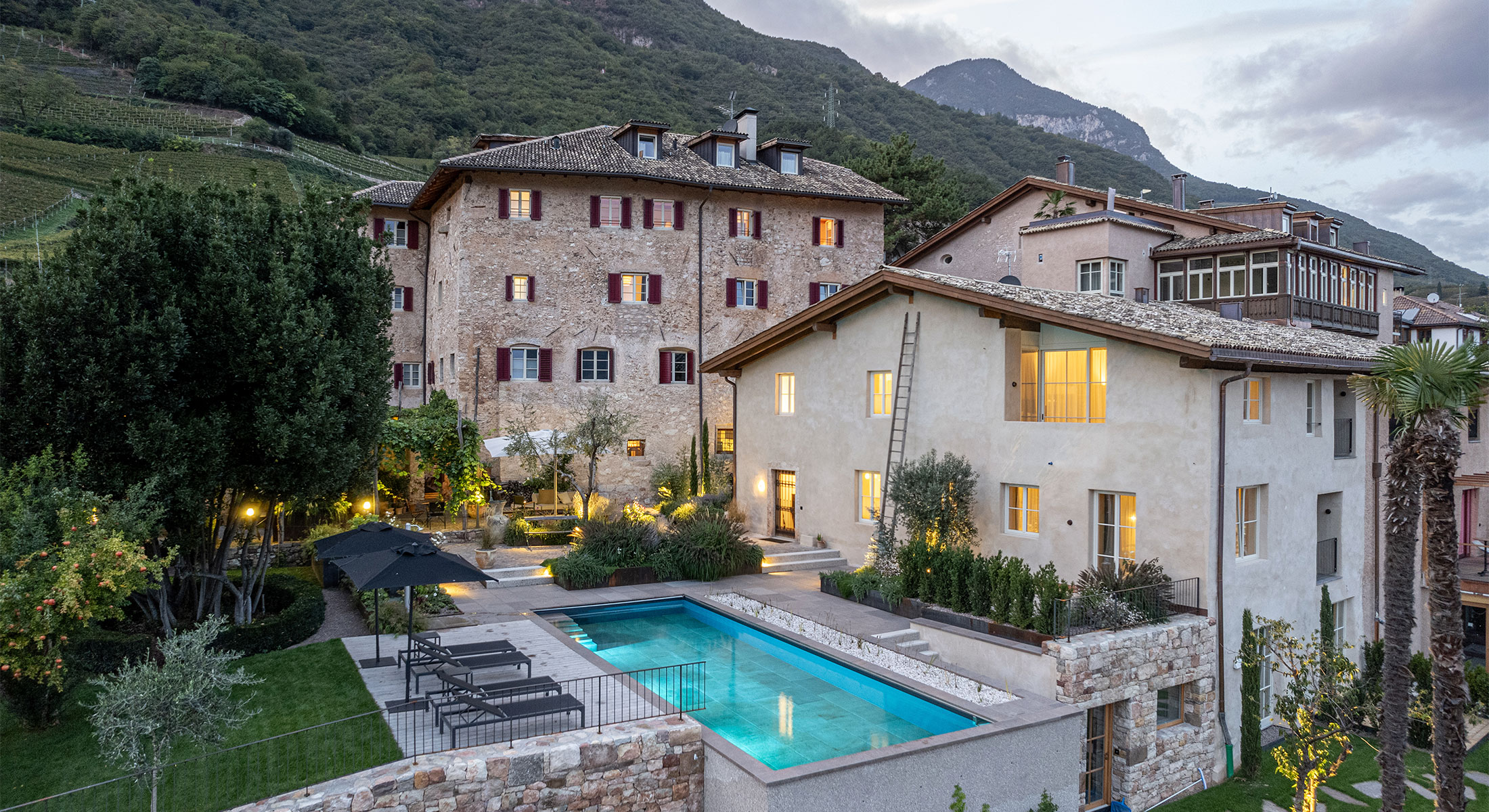 Ansitz Romani in Tramin am Abend mit beleuchtetem Bio-Pool – Hotel in Südtirol